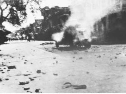 Archive photos: A military vehicle burns in the empty streets. | Image source - INP; courtesy - tribune.com.pk | Click for image.